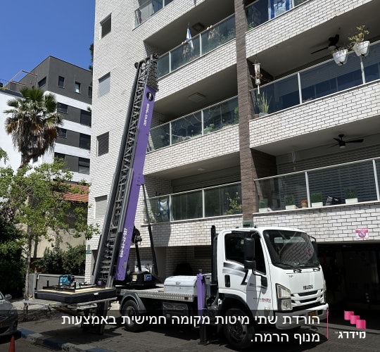 משאית עם מנוף סגול ליד בניין מגורים